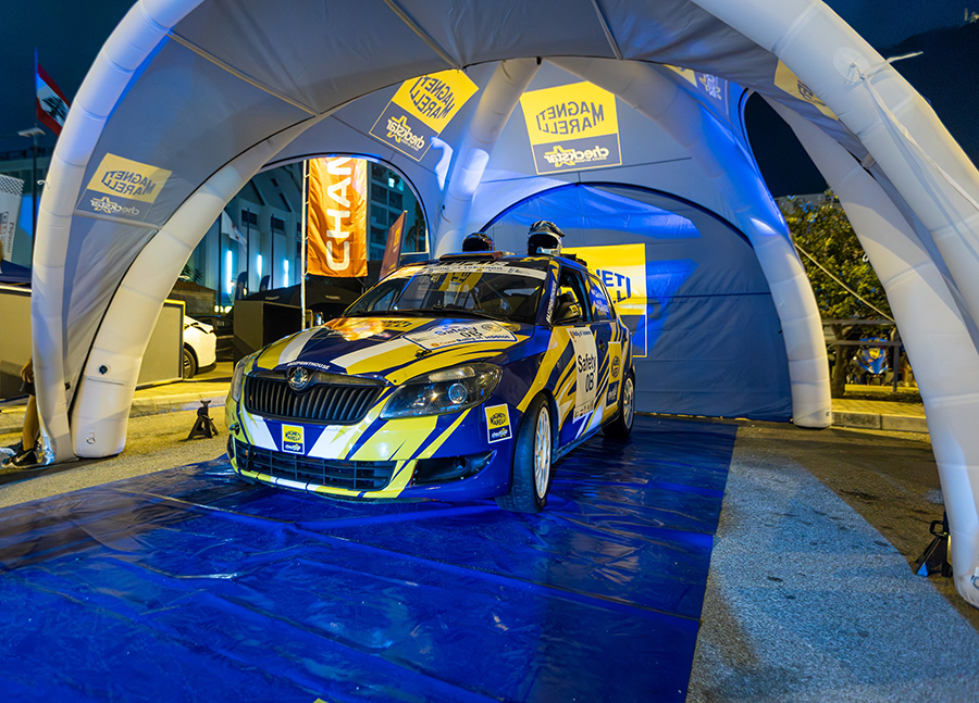 Magneti Marelli Checkstar rally car at night in branded display tent at 2025 Rally of Lebanon